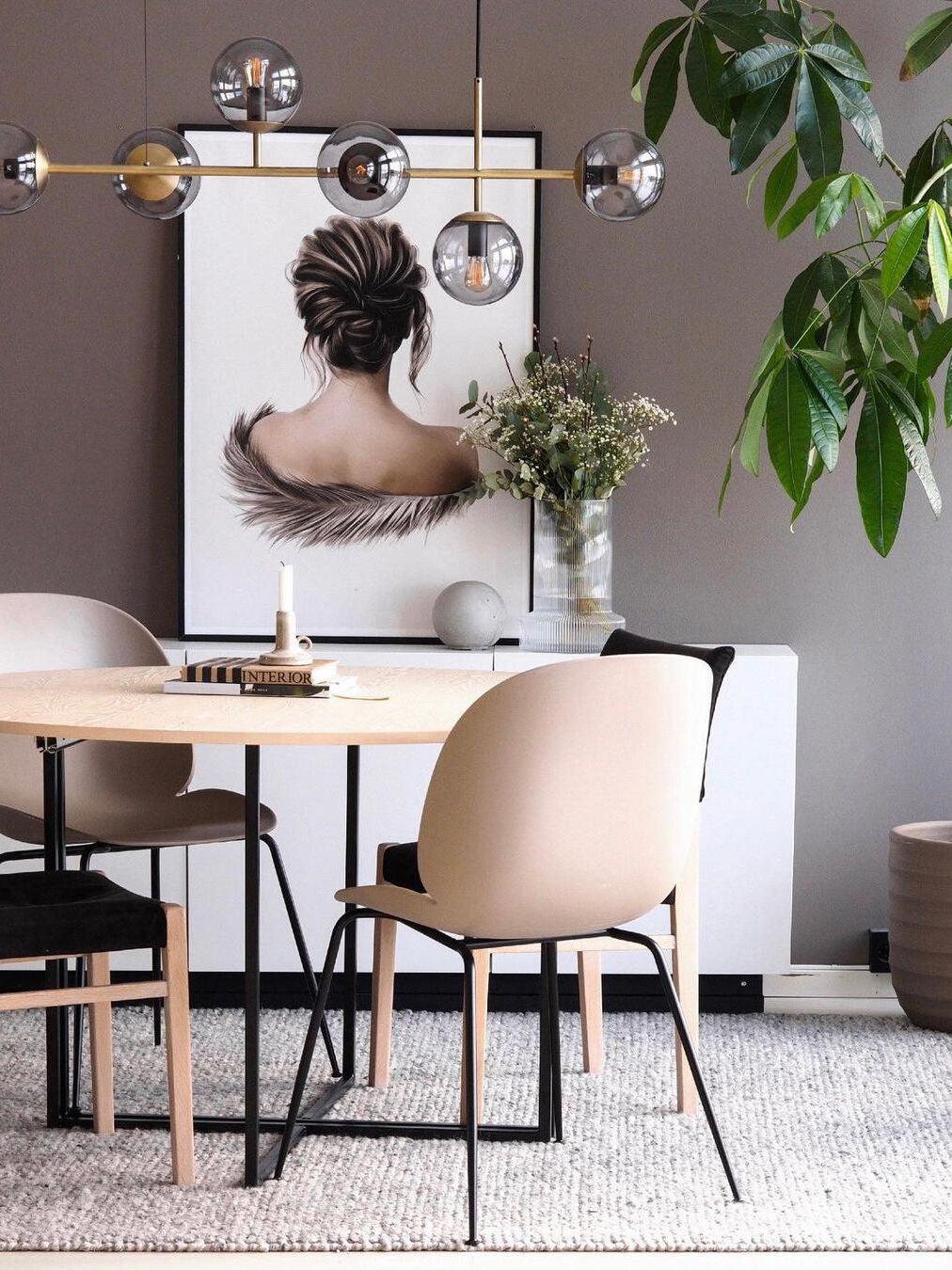 Orb chandelier above a table with pale chairs