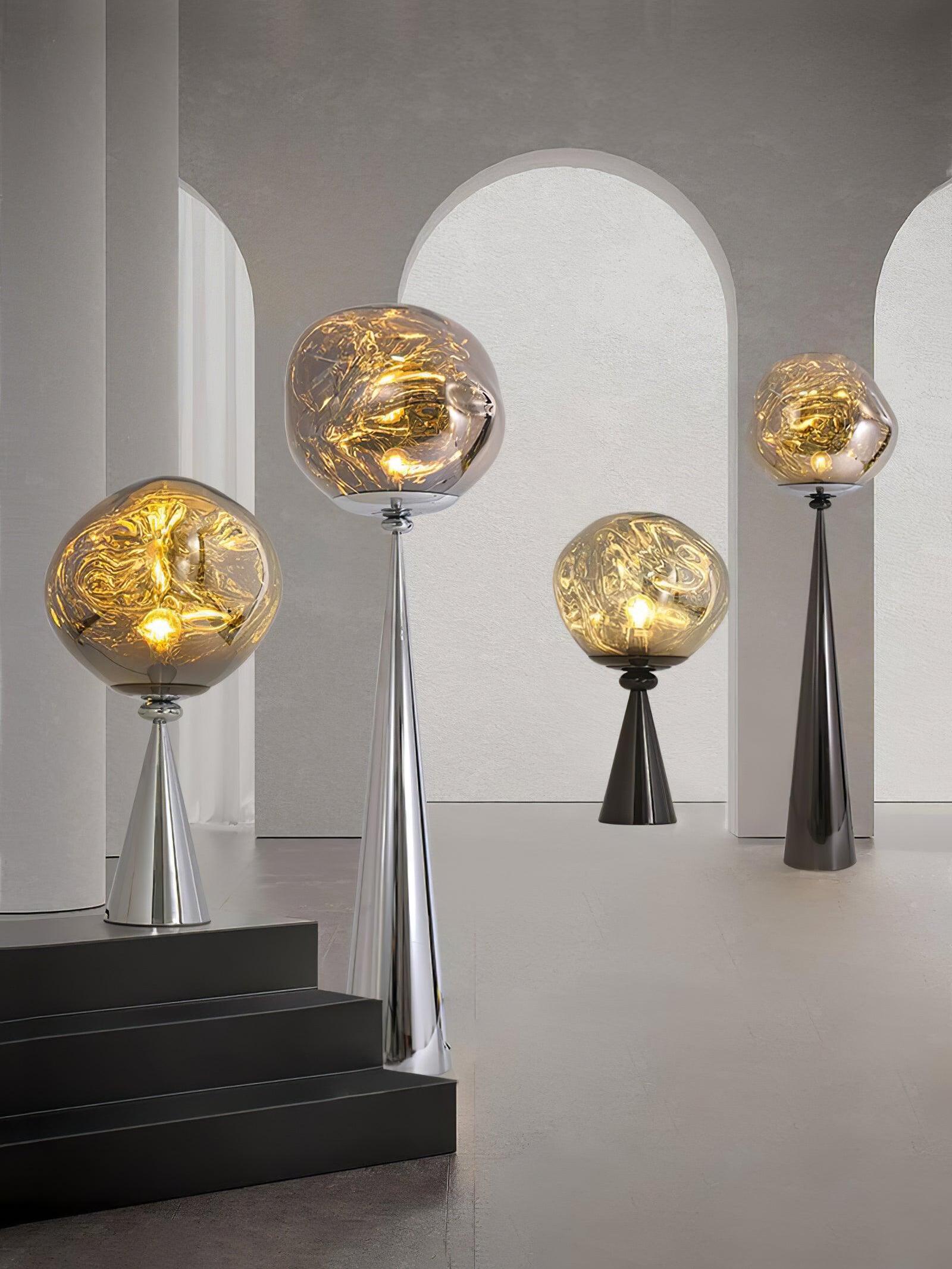 Four glowing globe lamps with chrome or black cone bases displayed among pale arch panels