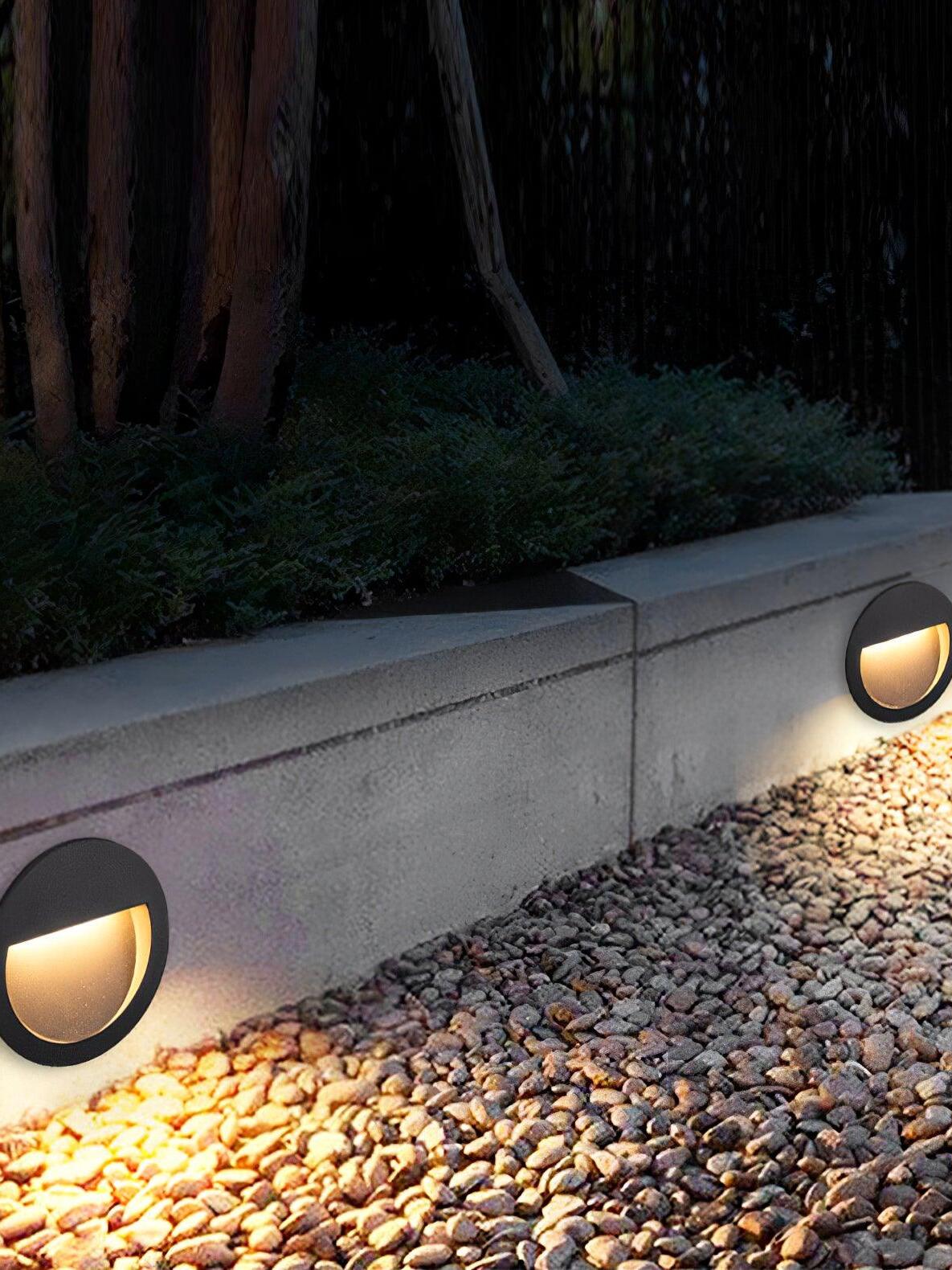 Round wall light above gravel border