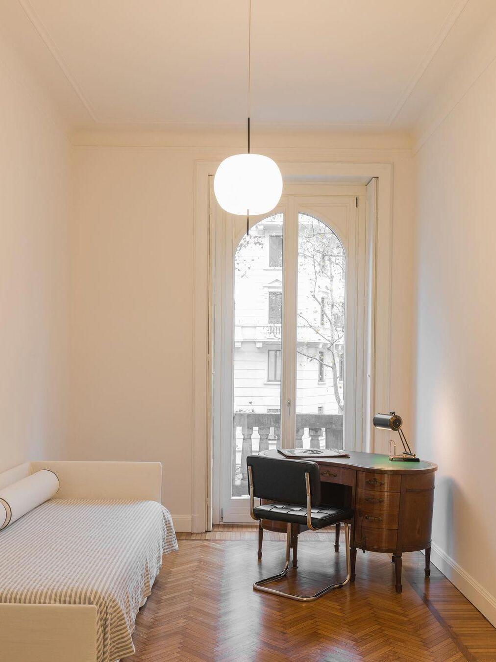 White rounded pendant in a room with an arched window