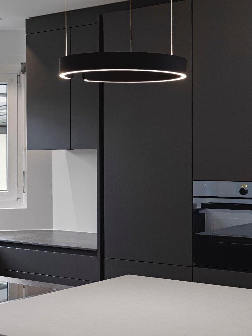Illuminated black ring near dark kitchen cabinets