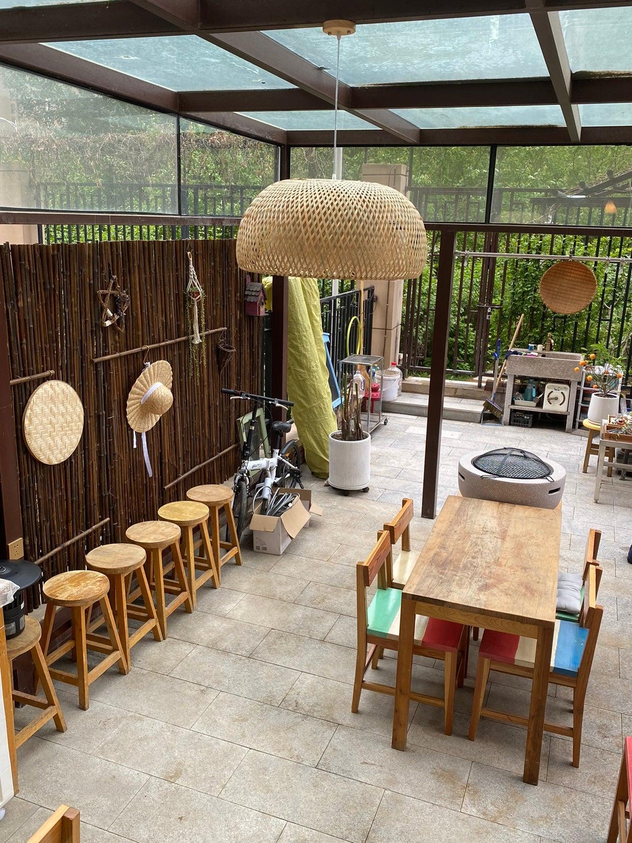 Natural woven pendant over table on roofed terrace