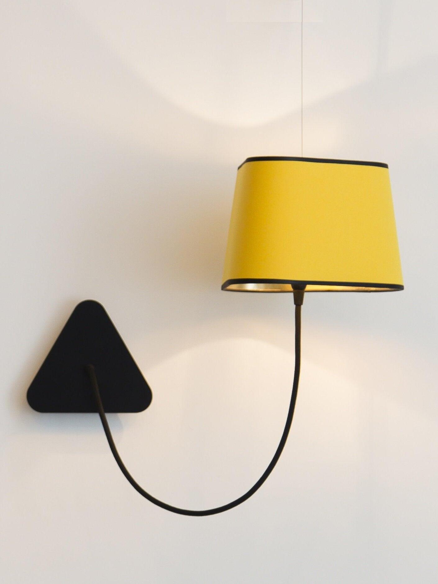 Yellow shade suspended above a looped black cord