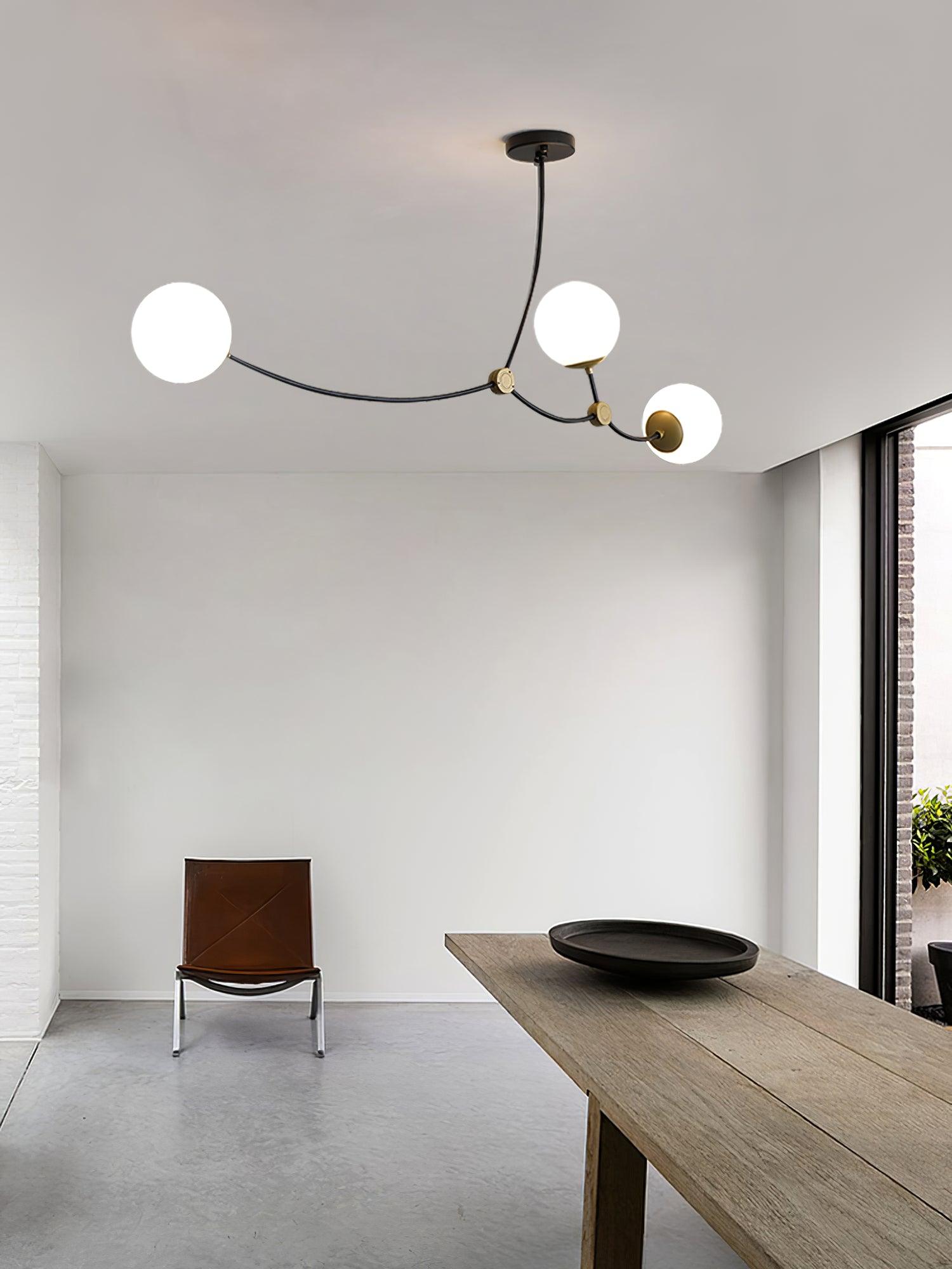 Black three-globe chandelier over a dining space