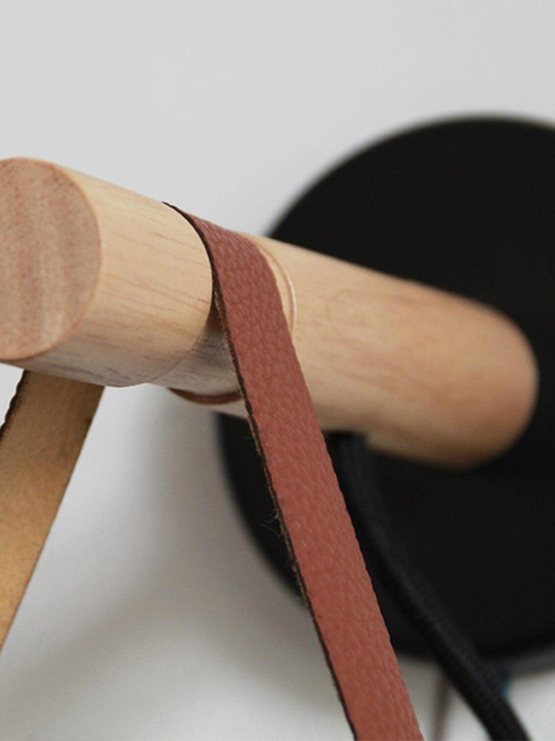 Brown strap looped around the wooden bar