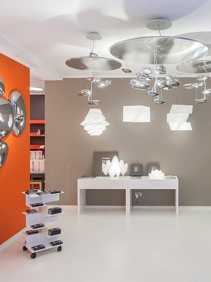 Reflective ceiling cluster in showroom among separate hanging and display lights