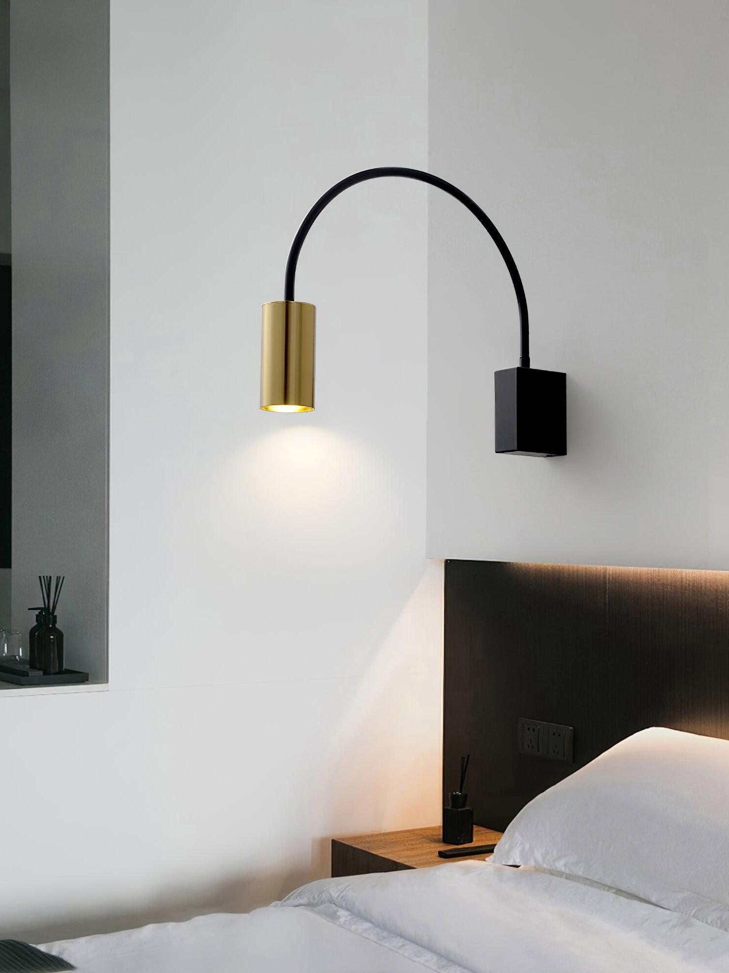 Gold-headed Antonella wall lamp above a bedside area