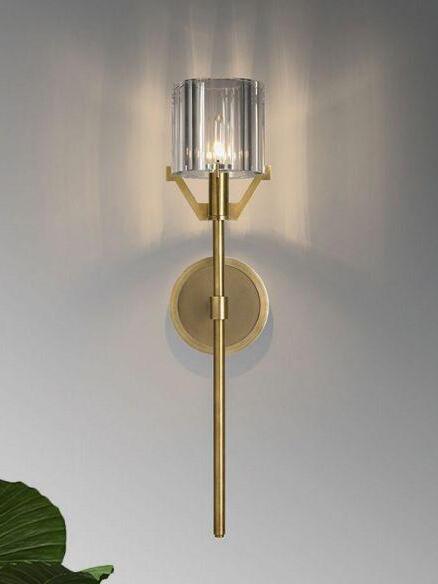 Gold Valdampierre fixture casting light on a pale wall
