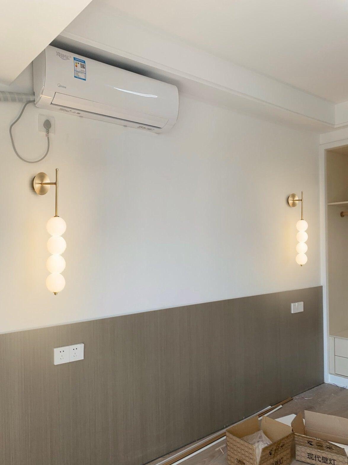 Matching Brass globe lights along a bedroom wall