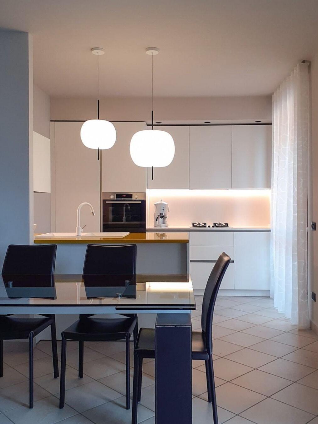 Two glowing white pendants above a kitchen table