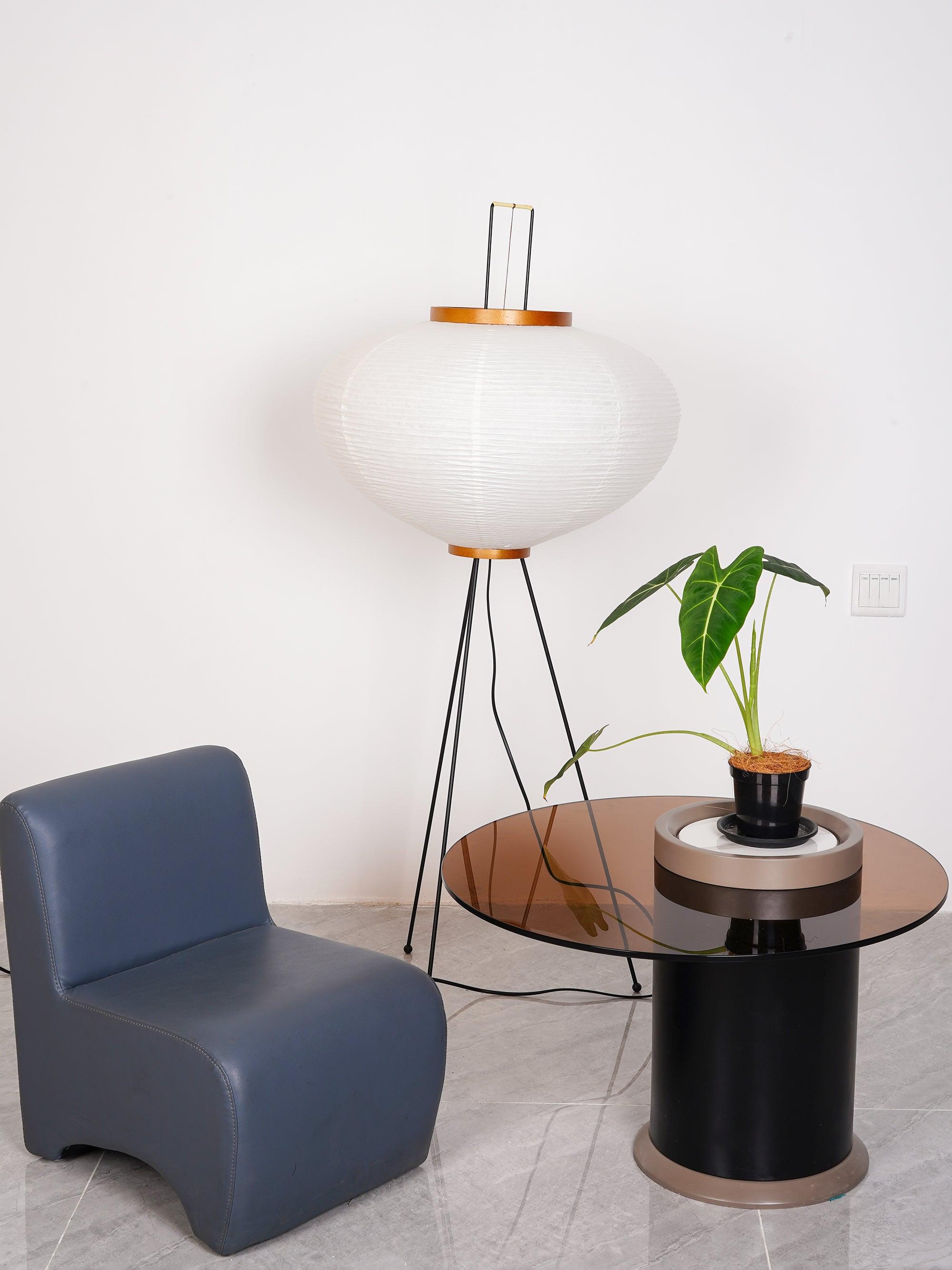 Rounded paper floor lamp beside blue chair