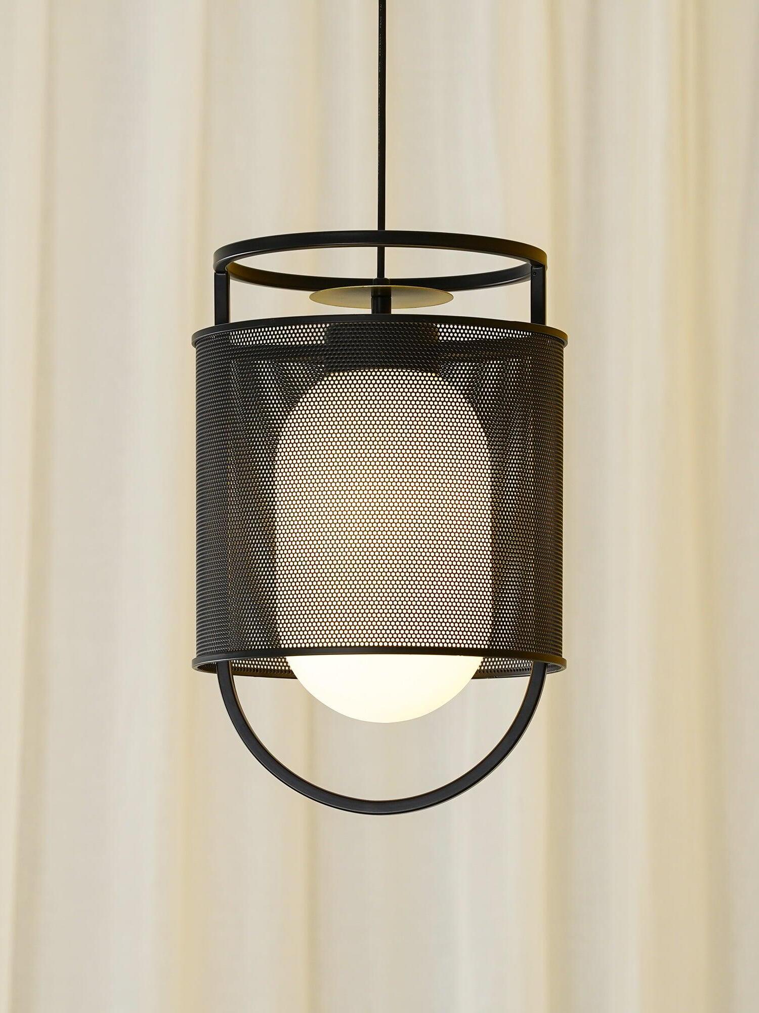 Black lantern pendant in front of pale curtains