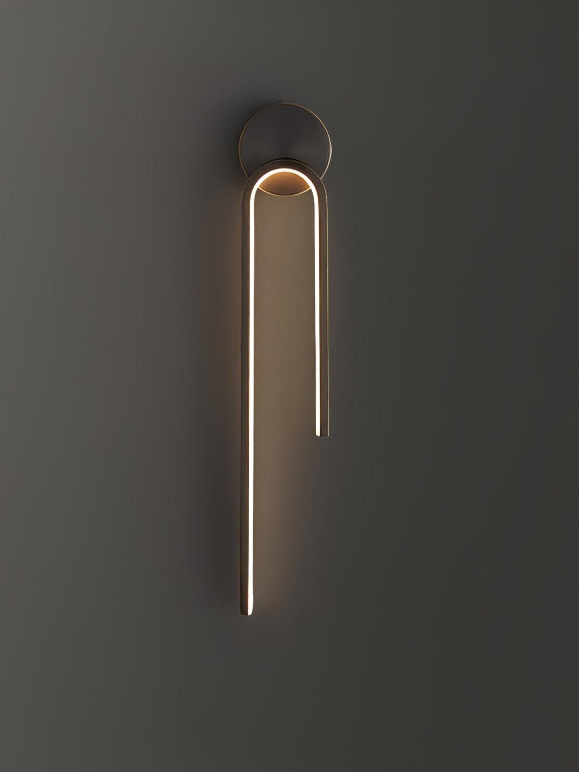 Dark asymmetric arch with a glowing inner strip and long left arm against a gray wall