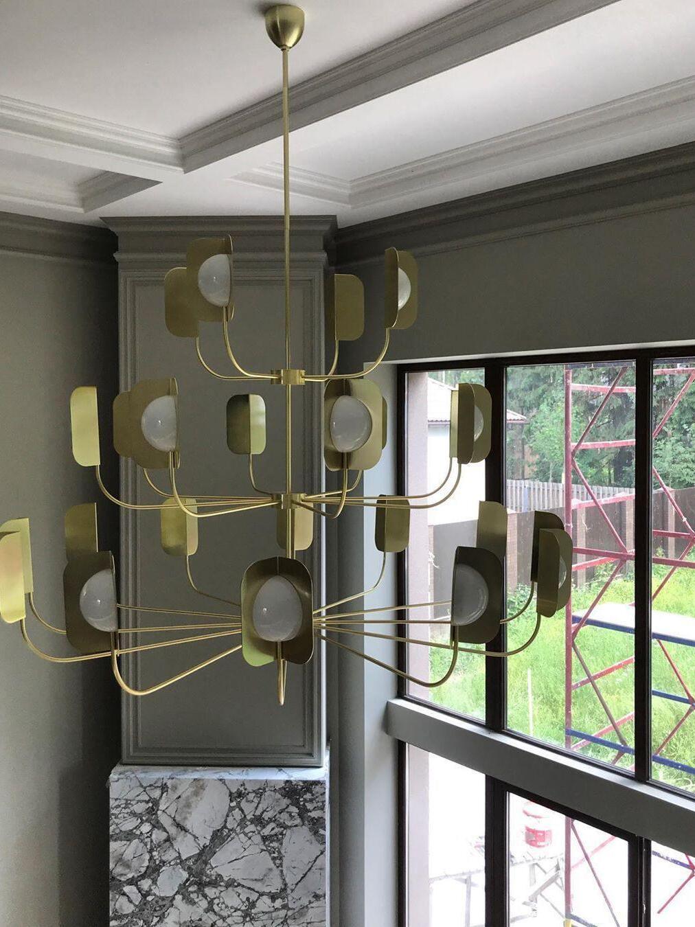 Large gold-coloured tiered chandelier near a window