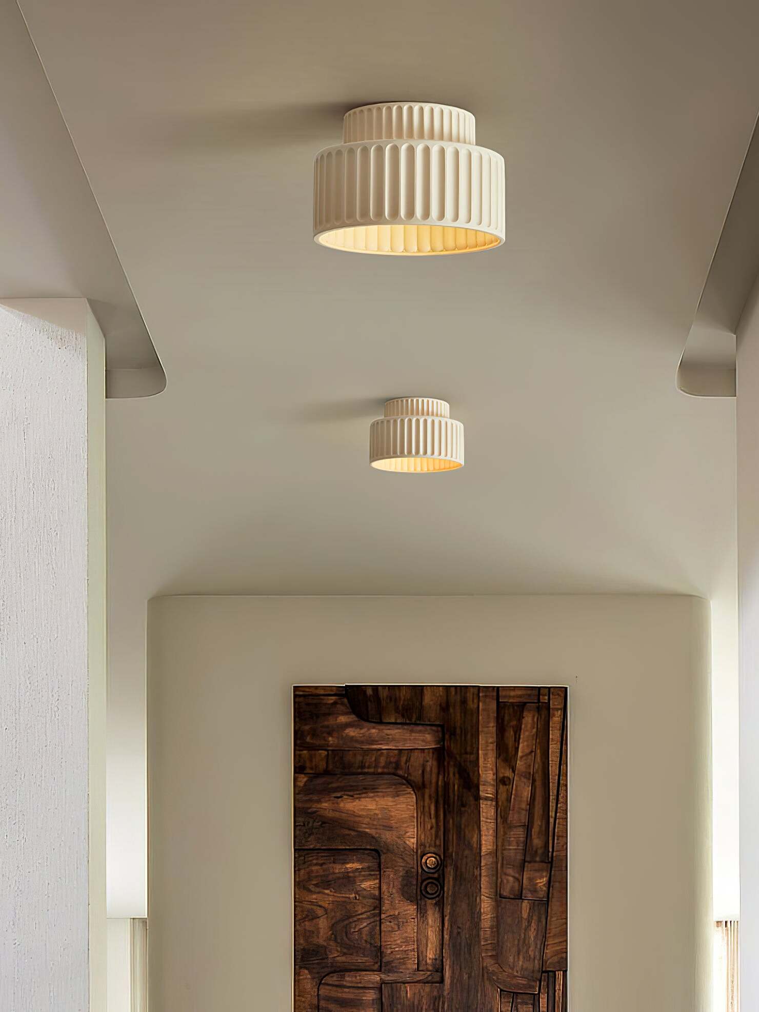 Two pale ribbed ceiling fixtures spaced along corridor