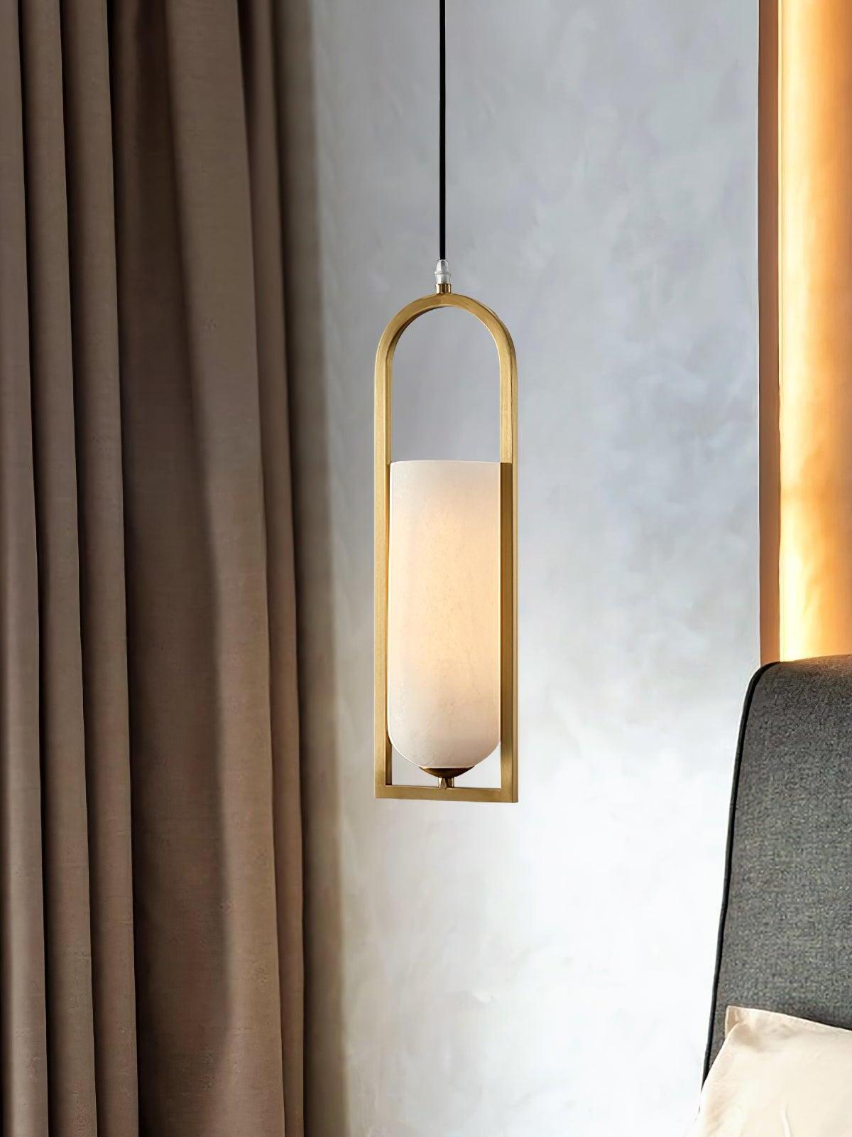 Melange pendant with a glowing white shade beside dark curtains and an upholstered bed