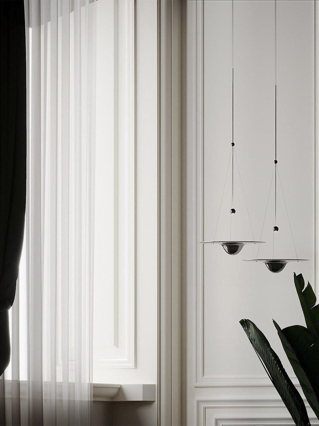 Pair of small glass disc pendants by curtain and plant
