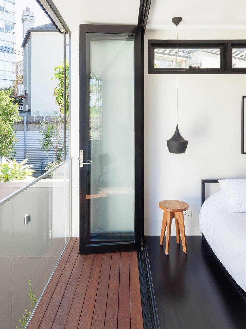 Single black pendant beside a bed