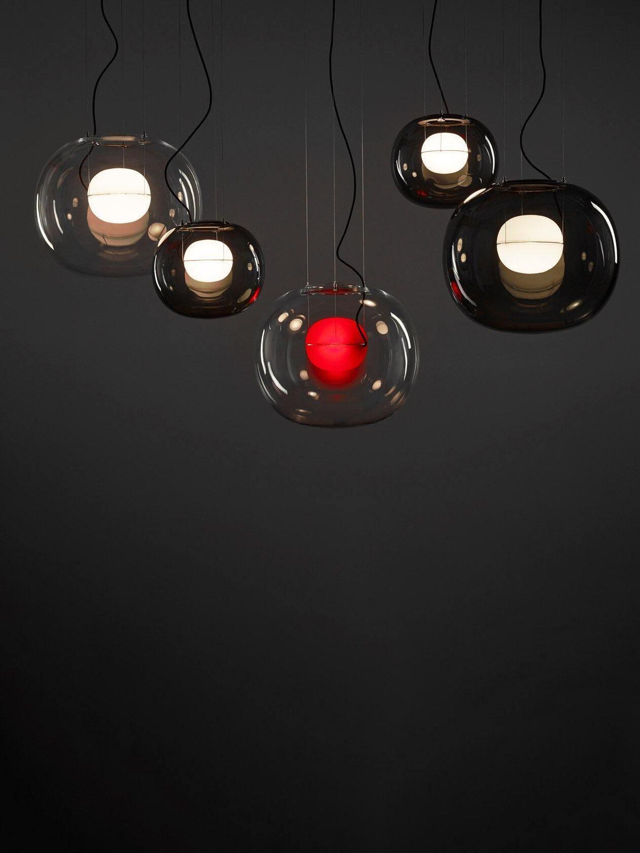 Globe pendant group with a red inner light against a dark wall