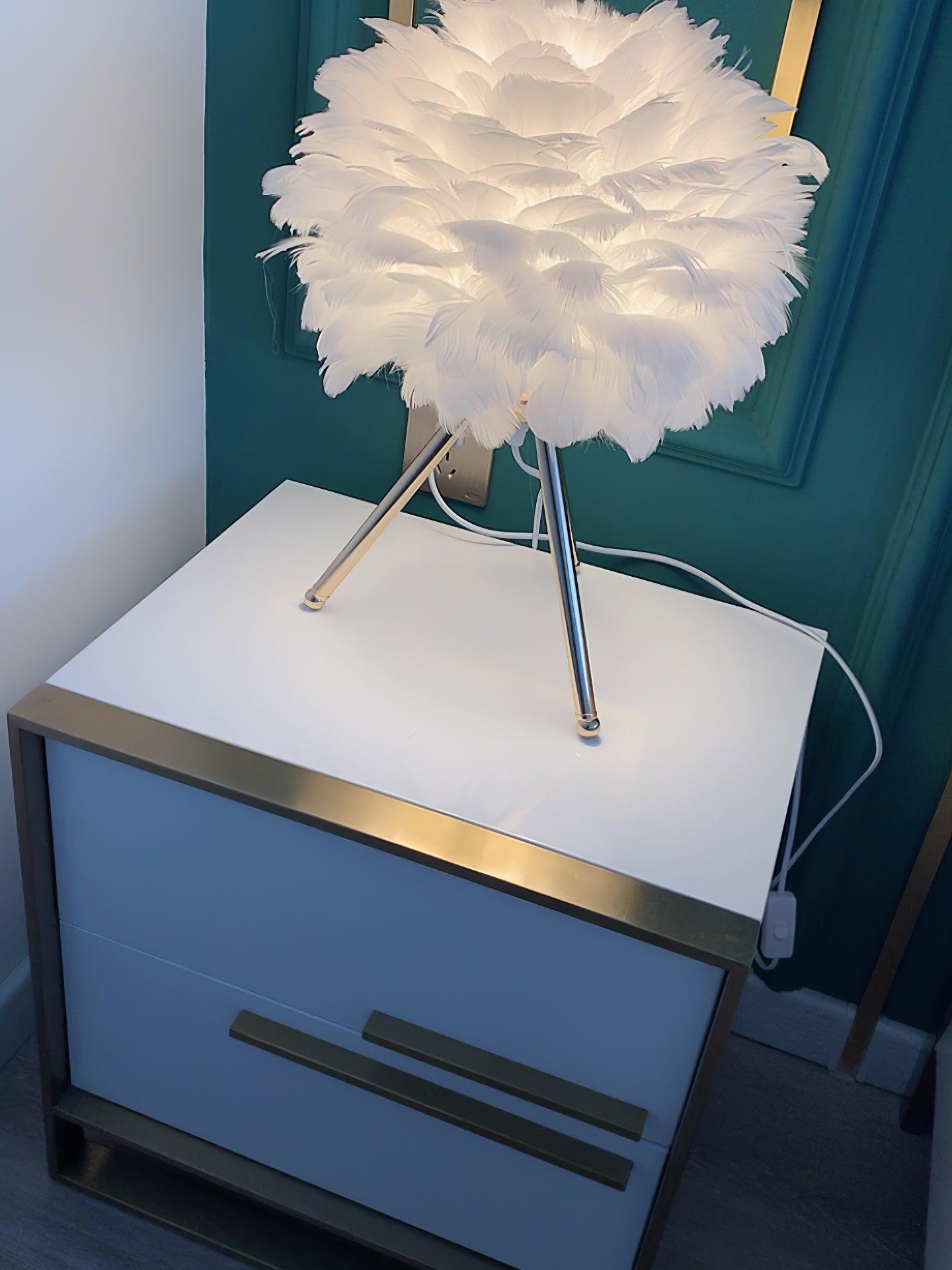 White feather lamp with white legs by blue cabinet