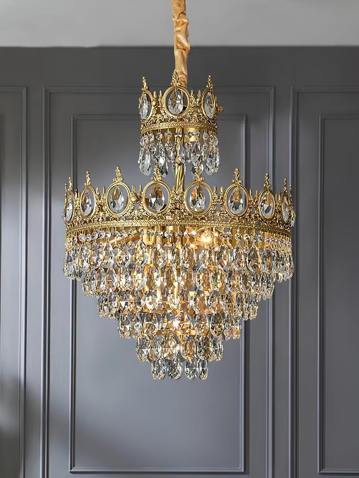 Crystal chandelier with a smaller upper crown and layered clear drops in front of dark grey wall panels