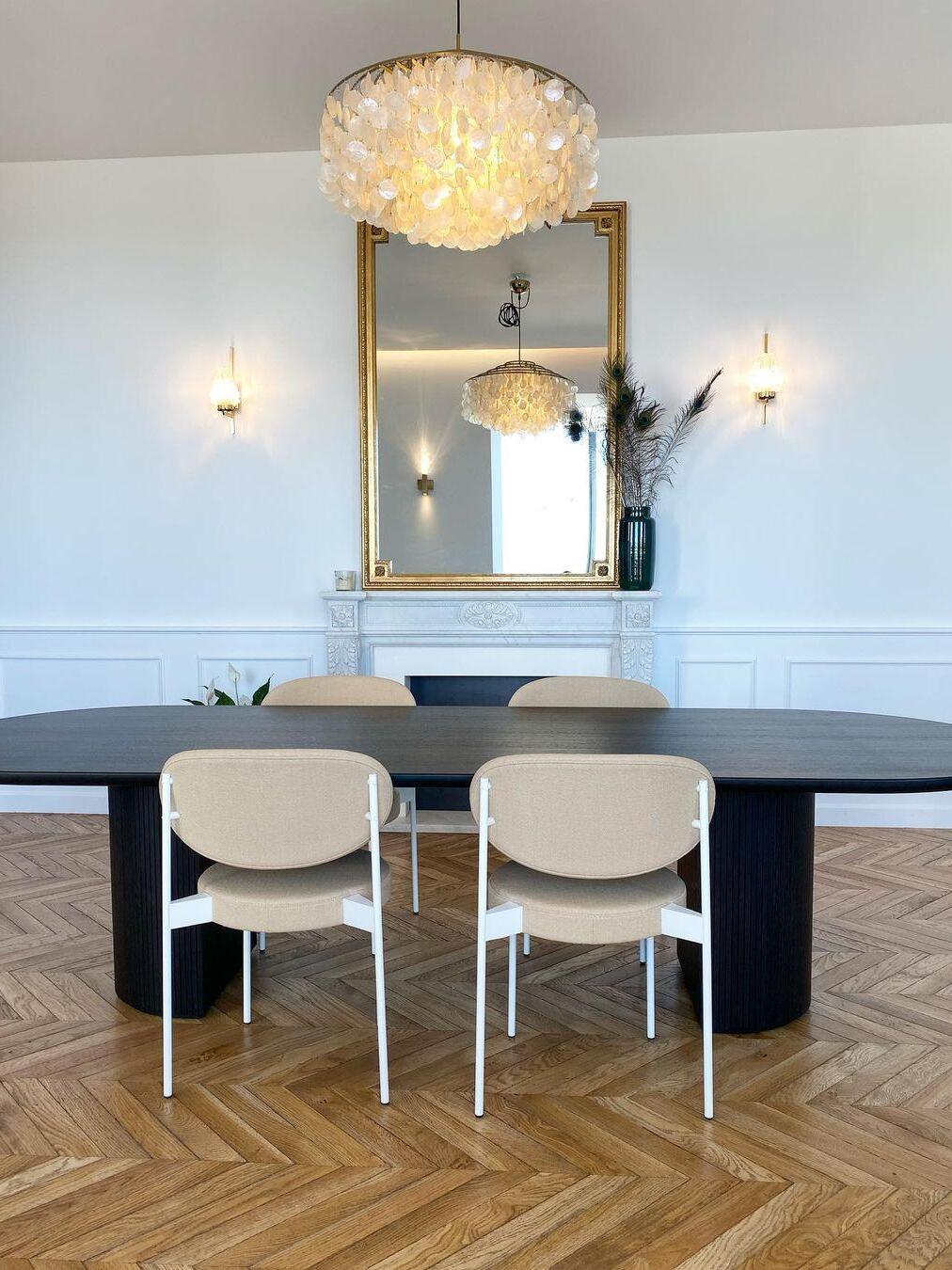 Round shell fixture above a table facing a mirror