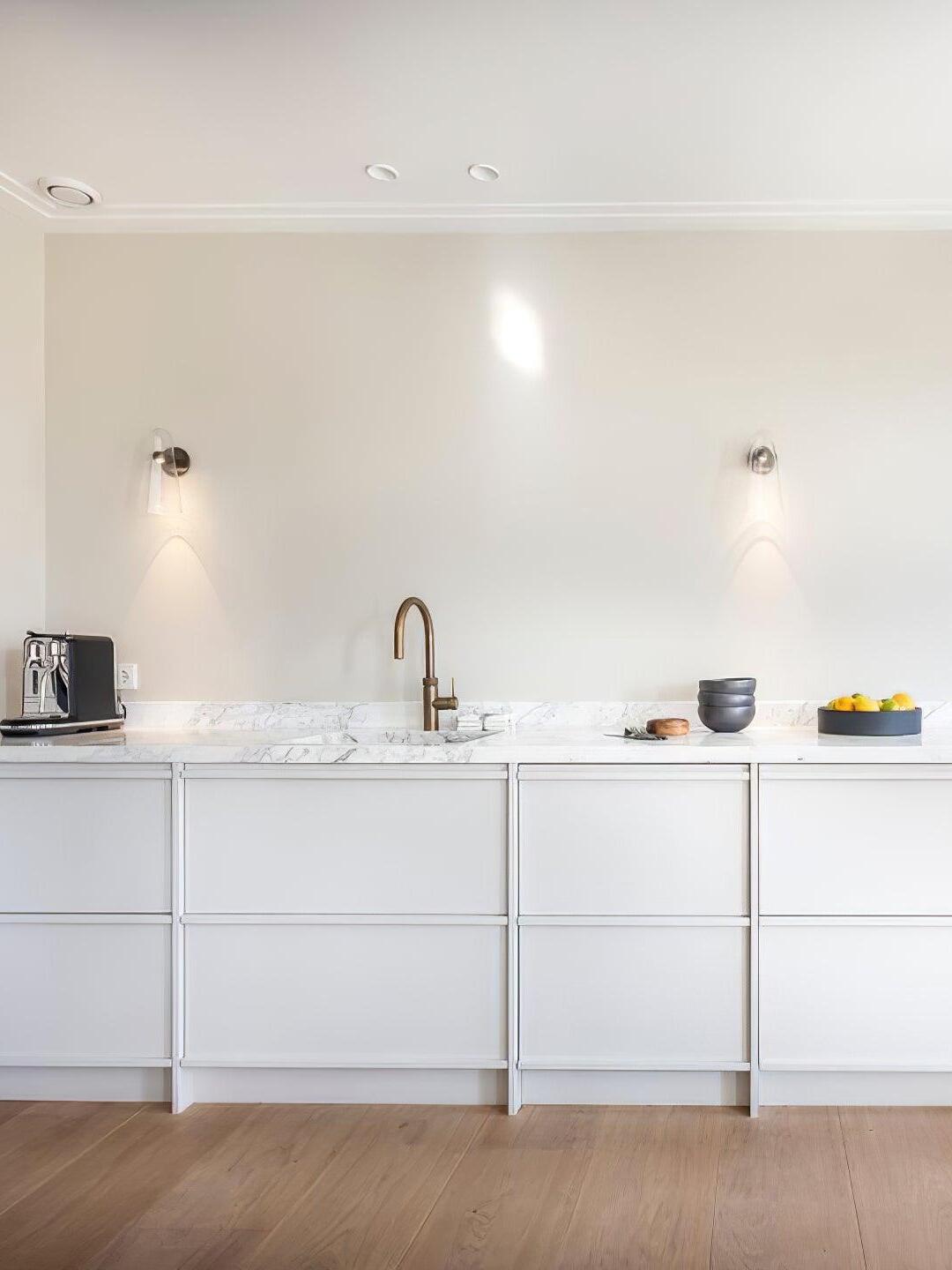 Small wall lights above a long white bathroom vanity