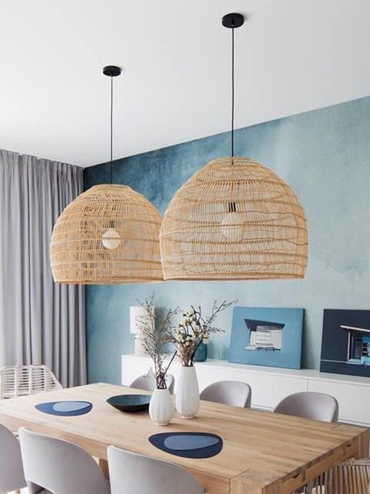 Two natural woven pendants above a dining table