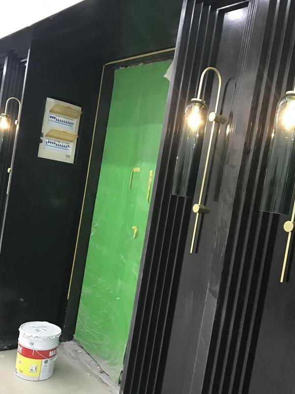 Tall glass wall lights beside dark vertical panels