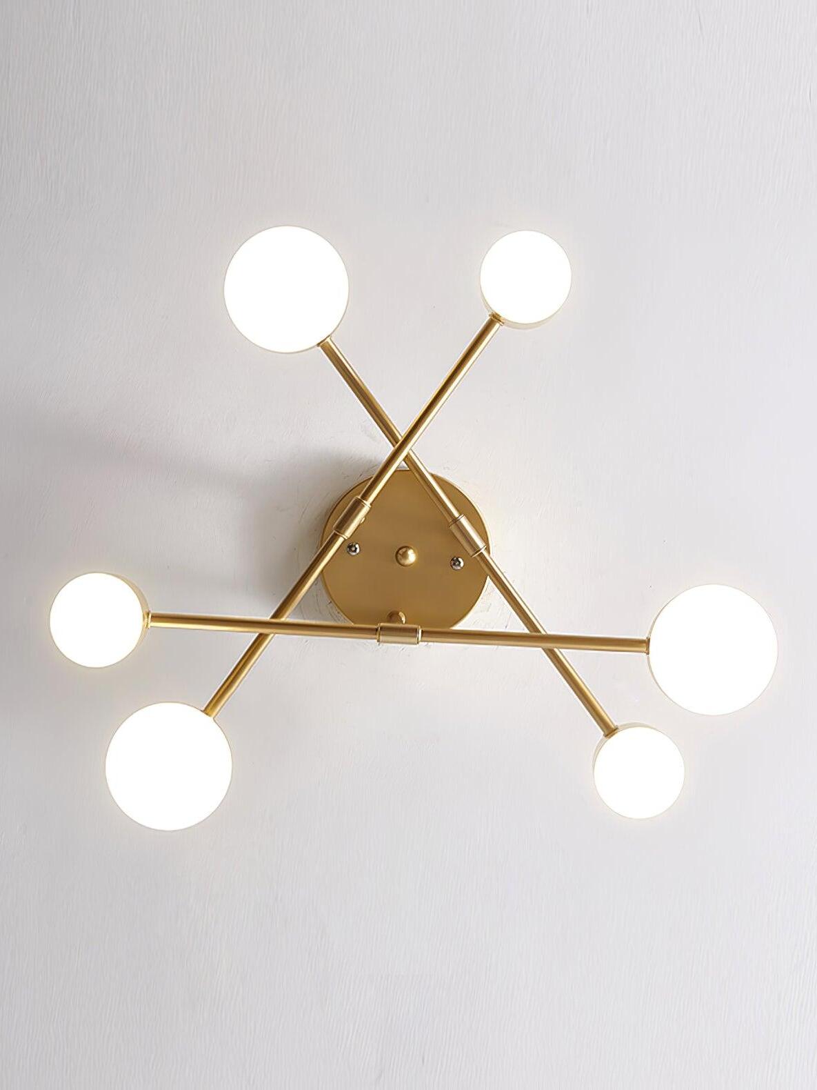 Direct underside view of three gold crossing arms and six glowing circular faces around a round ceiling canopy