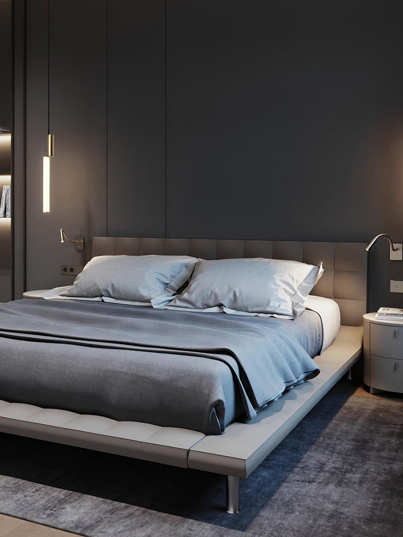 Gold-top luminous tube pendant beside dark bed