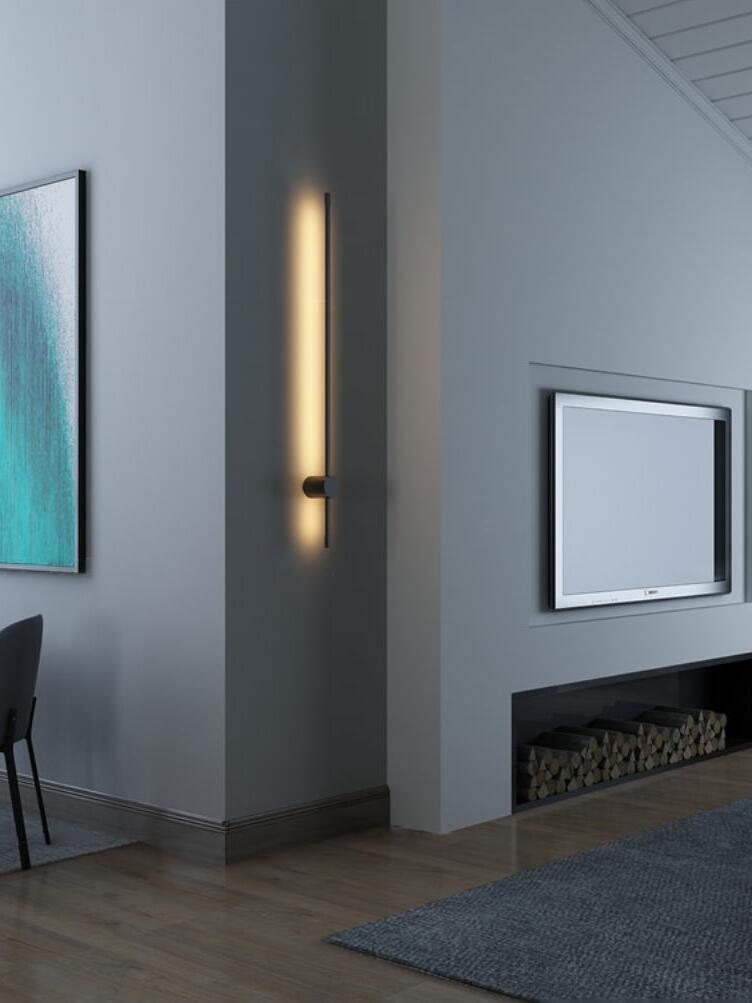 Tall linear wall light beside a fireplace