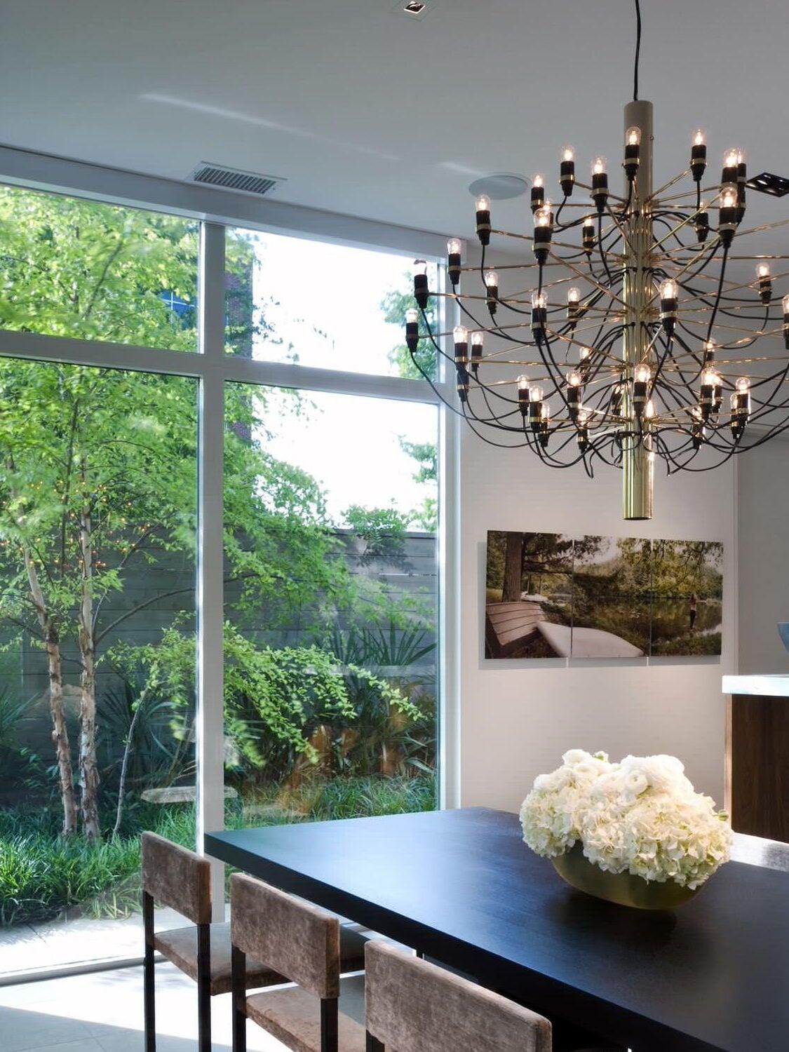 Tiered chandelier beside large dining-room windows