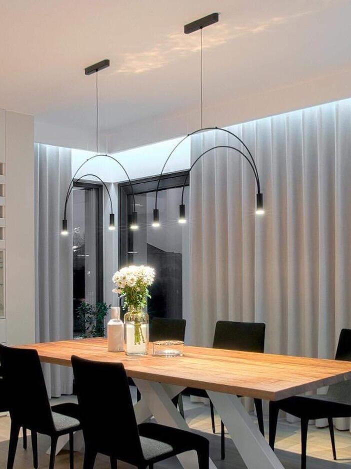 Black arched pendant above a dining table