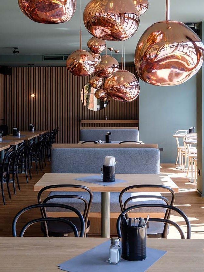 Copper-toned pendants above dining tables