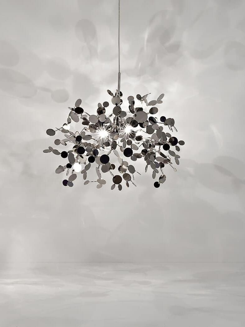 Silver disc cluster against a pale wall with soft disc-shaped shadows