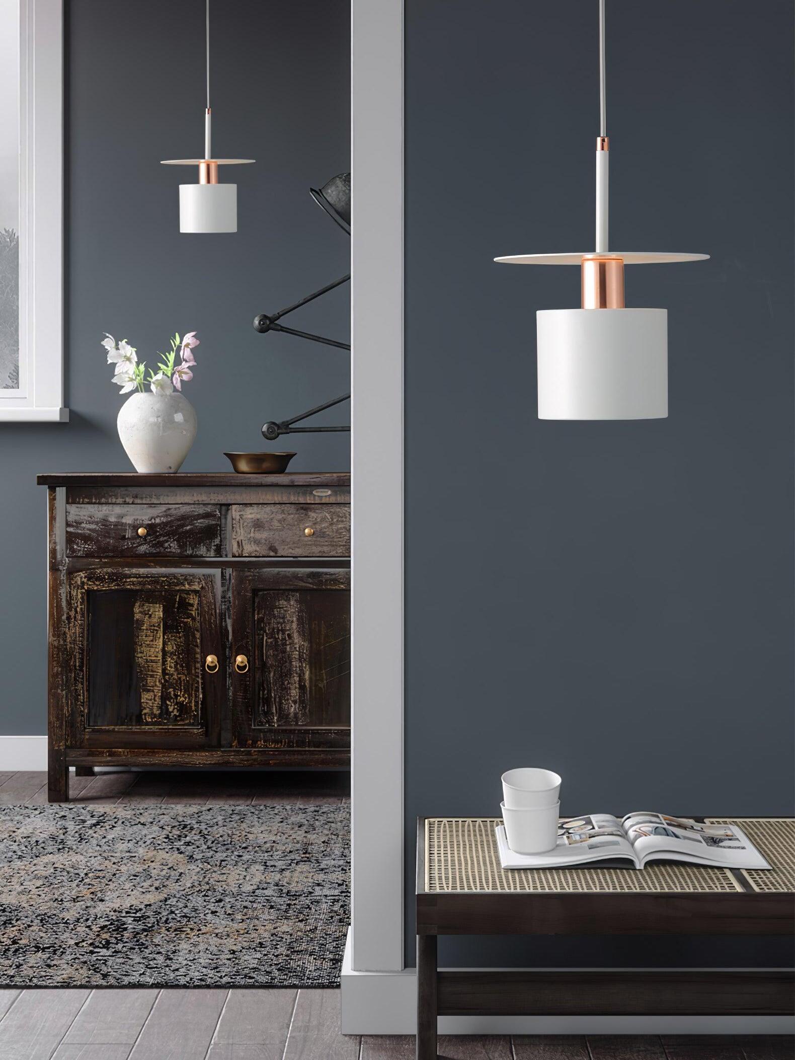 Two white disc pendants beside dark blue wall