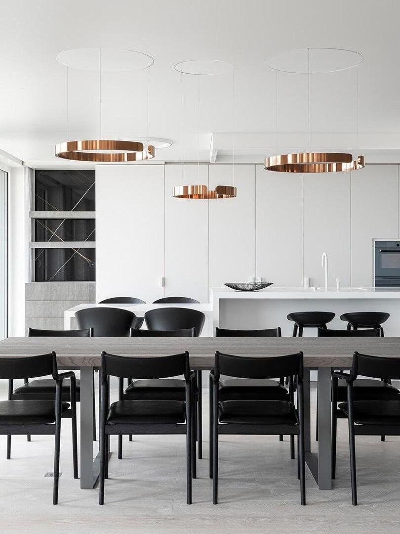 Metallic ring pendants above white dining tables