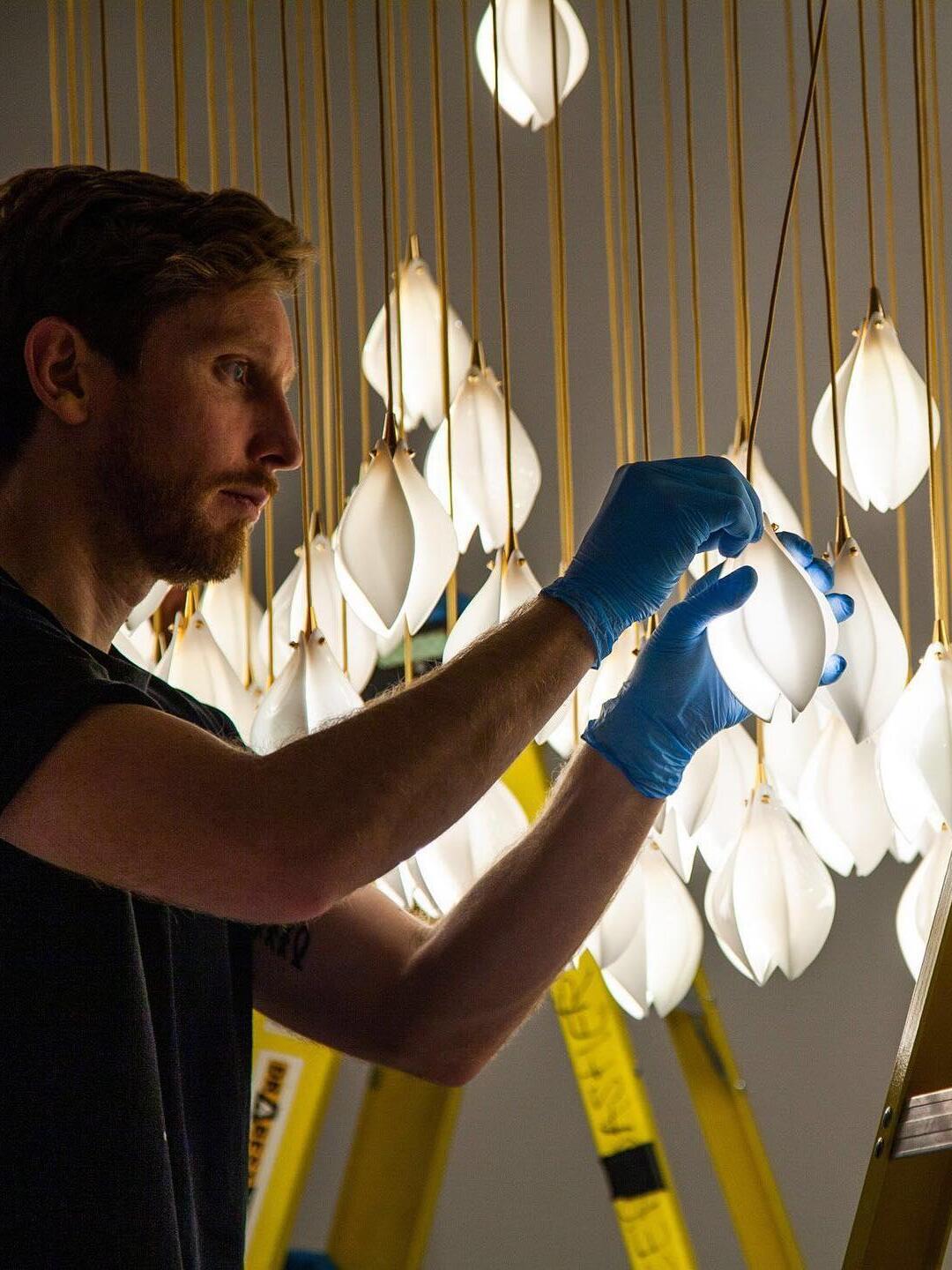 Person handling one bud in a large installation