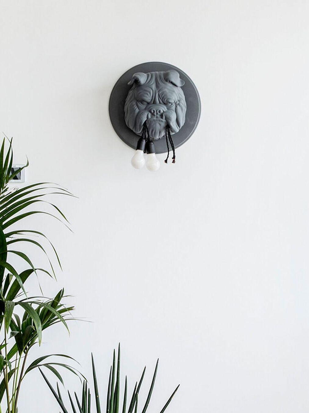 Dark sculpted bulldog head above indoor plants