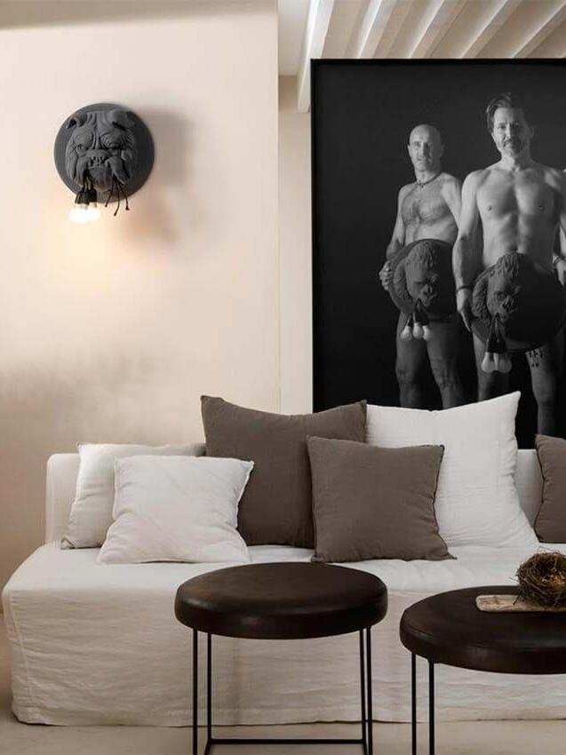 Dark bulldog wall light above a pale sofa