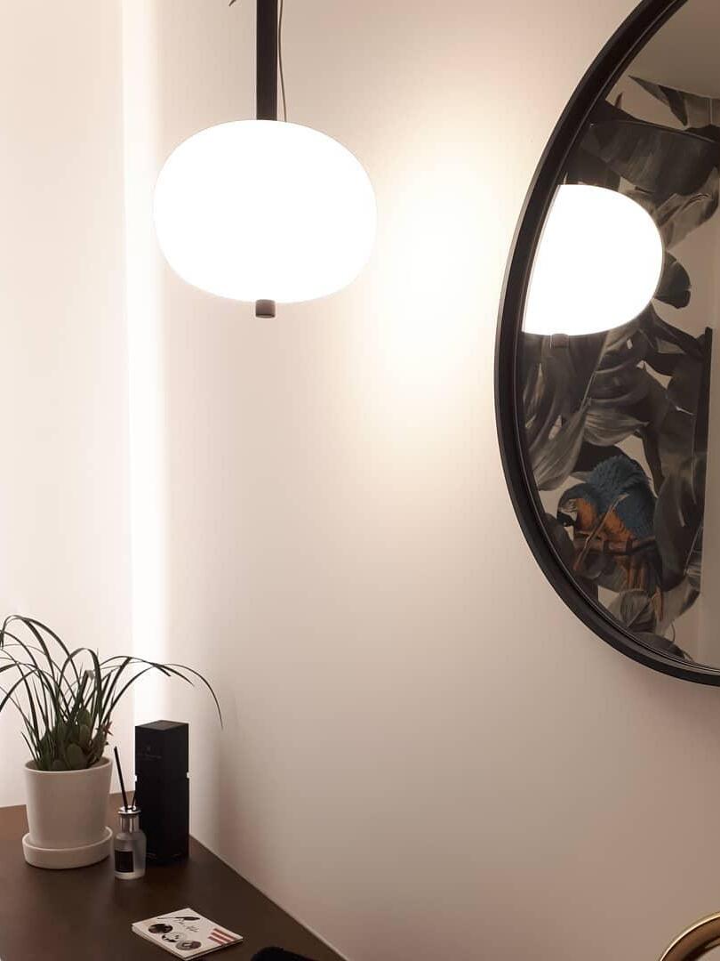 Single white globe beside a round mirror