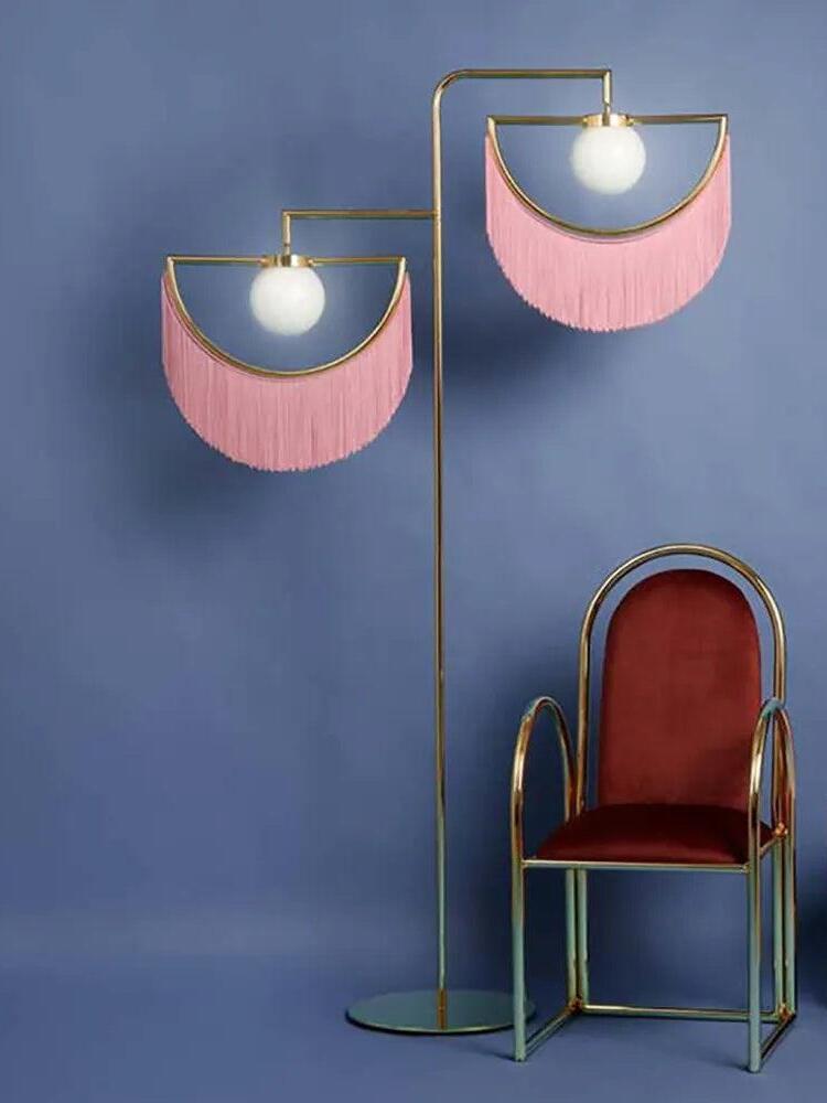 Wink pink two-head floor lamp beside an accent chair
