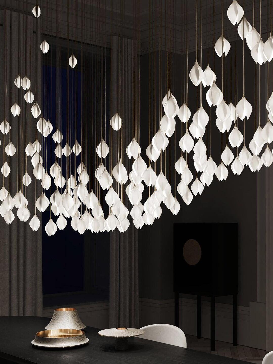 White petal-bud lights arranged in a broad curved line above a dining table
