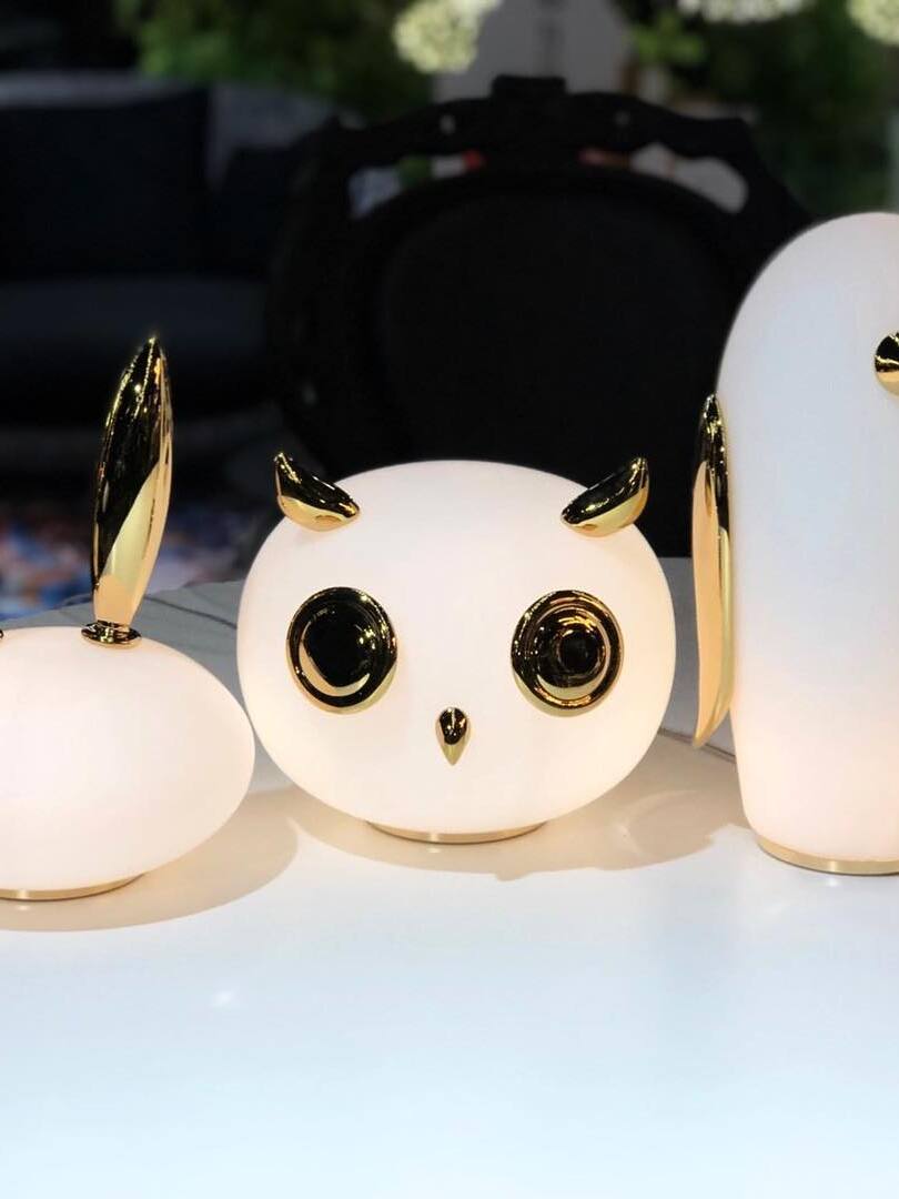 Owl in foreground with cropped rabbit and penguin among plants