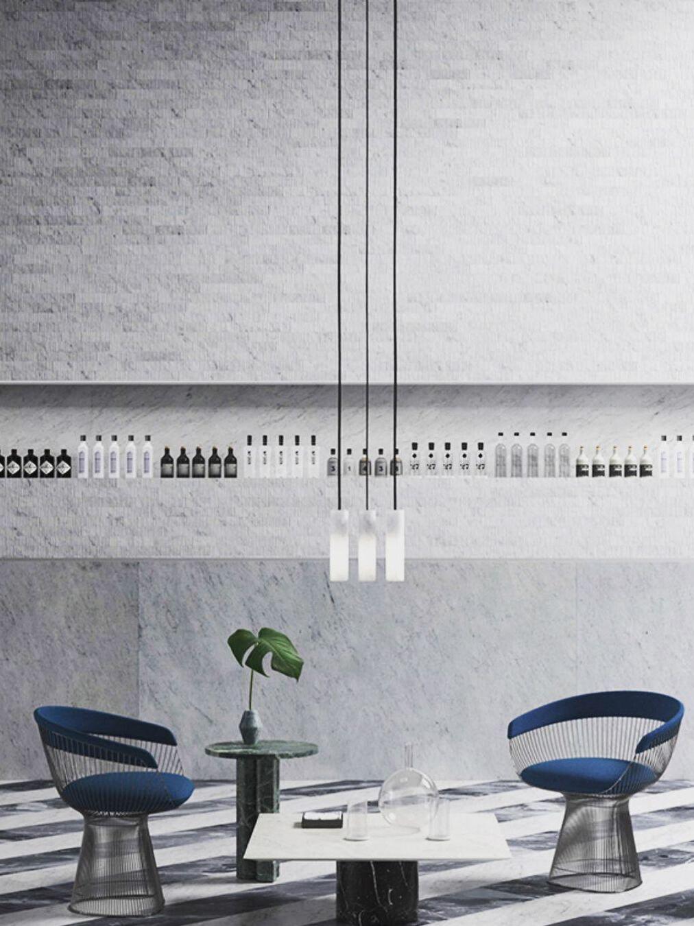 Three white Silo pendants on long cords above a low table between two blue chairs