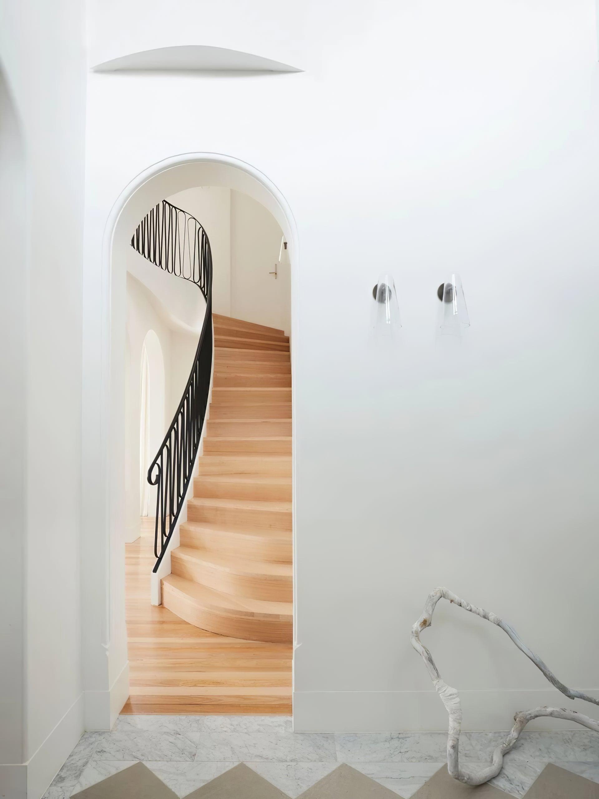 Small wall lights beside an arched doorway and stairs