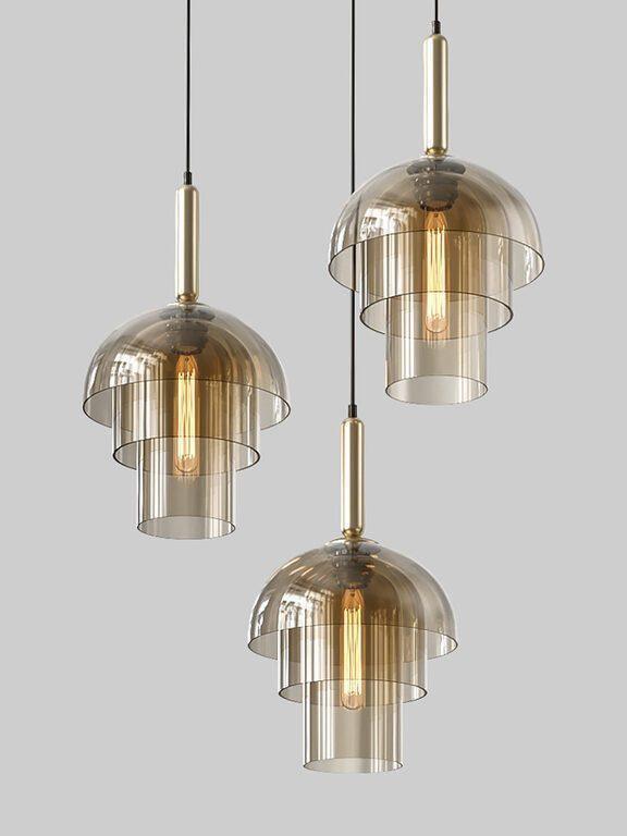 Three three-tier glass pendants at staggered heights on grey, with gold-tone fittings and visible filament bulbs