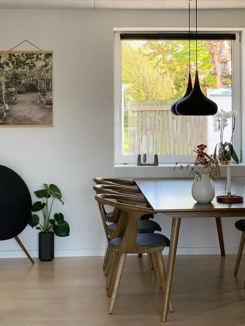 Black pendant above a wooden dining table
