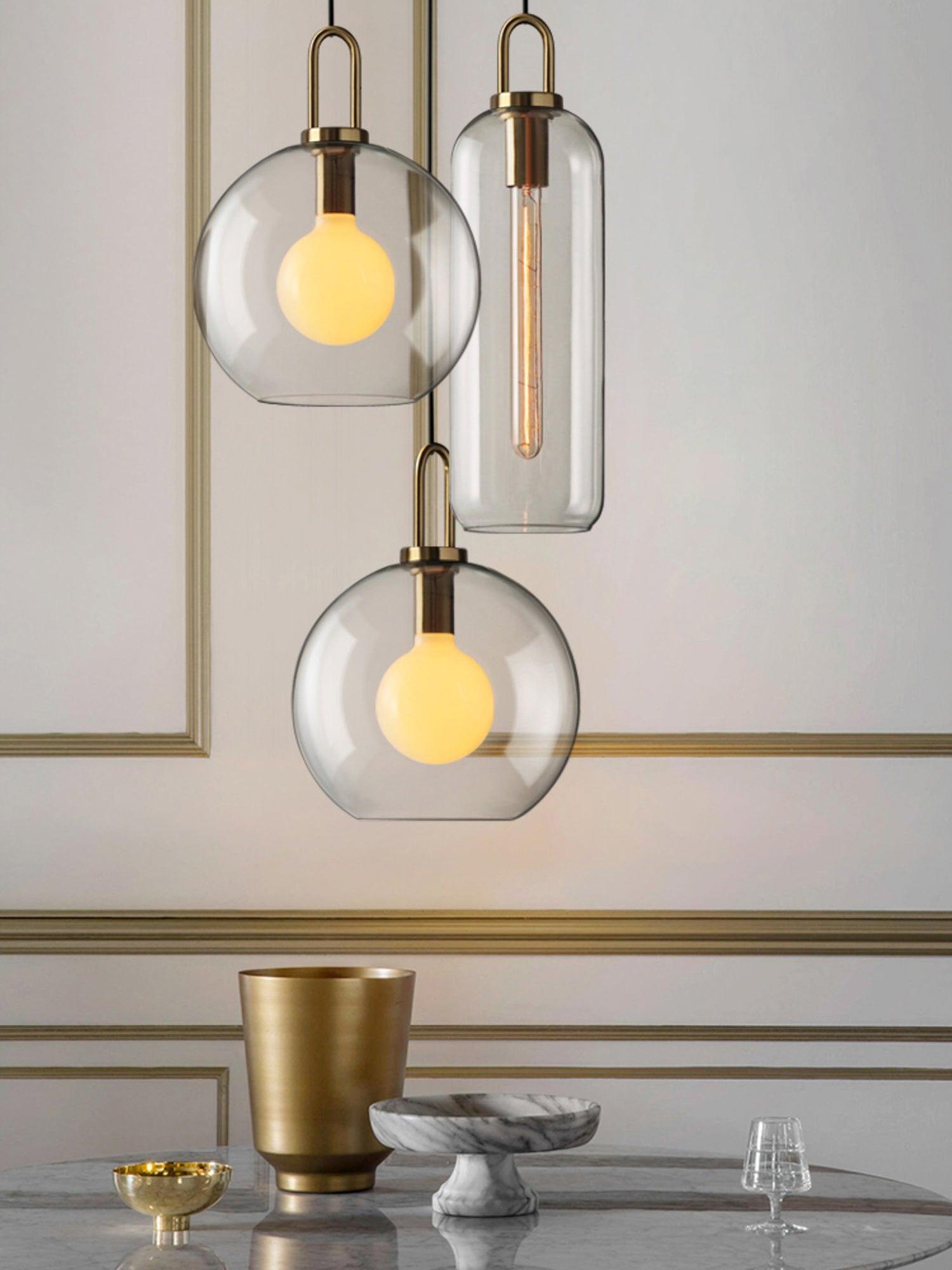 Mixed clear glass pendant group against a panelled wall